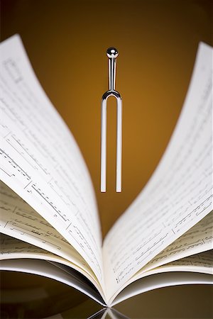 Close-up of a tuning fork and music sheets Stock Photo - Premium Royalty-Free, Code: 640-01363721