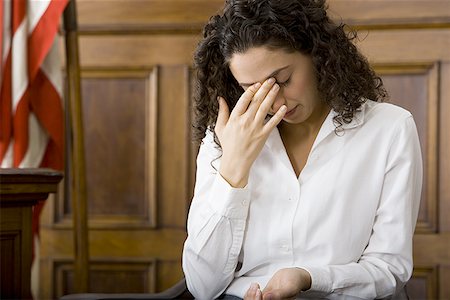 An upset female witness sitting in a courtroom Stock Photo - Premium Royalty-Free, Code: 640-01363763