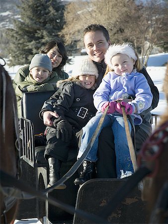Portrait of parents with their three children sitting in a carriage Stock Photo - Premium Royalty-Free, Code: 640-01363798