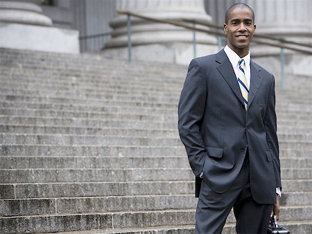 Portrait of a male lawyer standing on the steps of a courthouse and smiling Stock Photo - Premium Royalty-Free, Code: 640-01363810