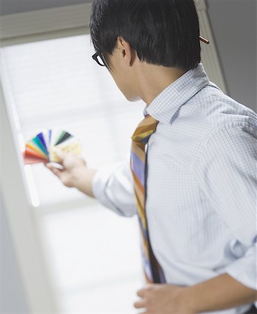 Profile of a businessman holding up color swatches Stock Photo - Premium Royalty-Free, Code: 640-01363890