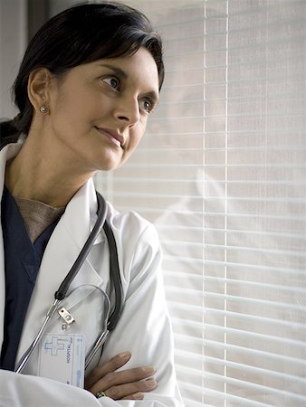 simsearch:649-06829838,k - Close-up of a female doctor leaning against a window with her arms crossed Fotografie stock - Premium Royalty-Free, Codice: 640-01363947