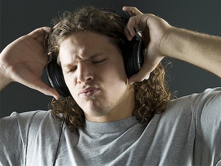 Close-up of a young man listening to the music on headphones Stock Photo - Premium Royalty-Free, Code: 640-01363995