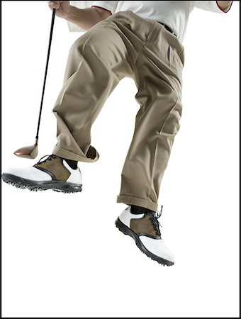 Low section view of a mid adult man jumping with a golf club Stock Photo - Premium Royalty-Free, Code: 640-01363990