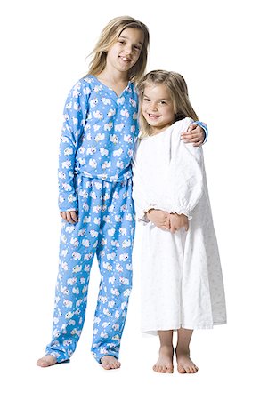 Two girls in pajamas hugging and smiling Stock Photo - Premium Royalty-Free, Code: 640-01458480