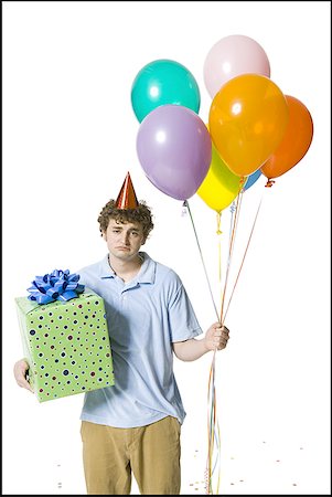 party baloons cutouts - Man with party hat holding balloons and gift box looking sad Stock Photo - Premium Royalty-Free, Code: 640-01458503