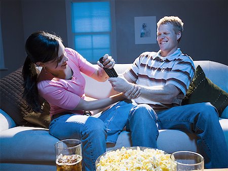 Couple fighting over television remote Stock Photo - Premium Royalty-Free, Code: 640-01458595