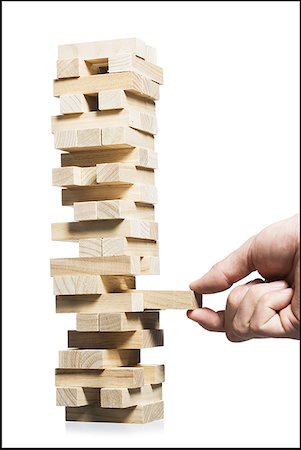 Hand removing block from stack of wooden blocks Stock Photo - Premium Royalty-Free, Code: 640-01458612