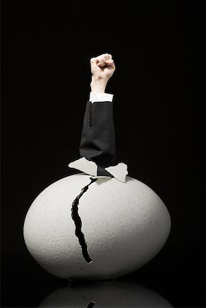 Cracked egg with clenched fist in business suit emerging Stock Photo - Premium Royalty-Free, Code: 640-01458631