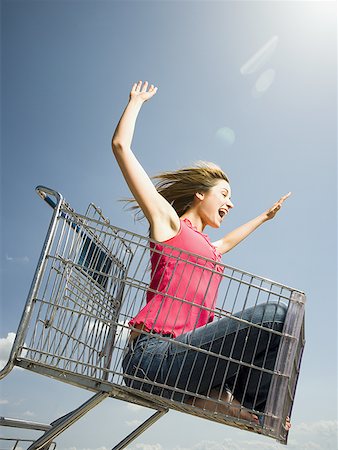 simsearch:640-02773934,k - Woman in shopping cart outdoors with arms up smiling Foto de stock - Royalty Free Premium, Número: 640-01458852