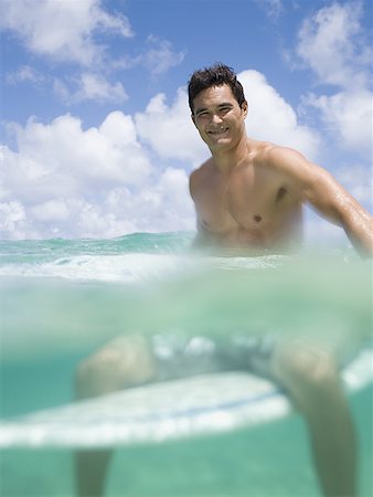 surfer underwater - Man sitting on surfboard in water smiling Stock Photo - Premium Royalty-Free, Code: 640-01458962