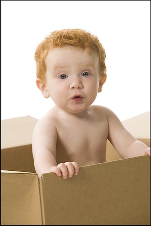 funny baby surprised expression - Baby boy in cardboard box making funny face Stock Photo - Premium Royalty-Free, Code: 640-01459074