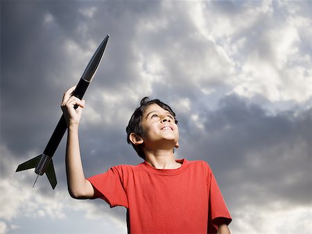 esplorazione spaziale - Boy playing with toy rocket outdoors Fotografie stock - Premium Royalty-Free, Codice: 640-01574906