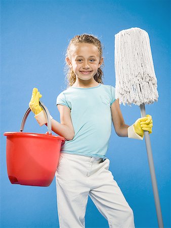Girl holding mop and bucket with rubber gloves smiling Stock Photo - Premium Royalty-Free, Code: 640-01574937