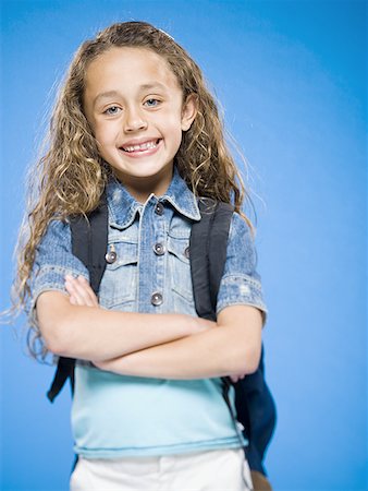 Smiling girl with arms crossed and backpack Stock Photo - Premium Royalty-Free, Code: 640-01574931