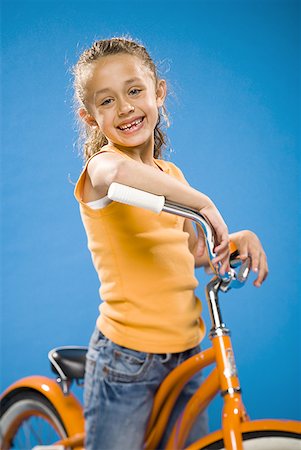 simsearch:640-01351999,k - Girl on orange bicycle smiling Stock Photo - Premium Royalty-Free, Code: 640-01574941