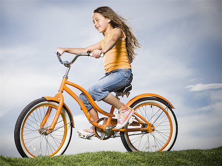 simsearch:640-01354982,k - Girl on orange bicycle outdoors smiling Stock Photo - Premium Royalty-Free, Code: 640-01574954