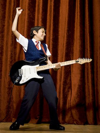 Boy on stage playing electric guitar Stock Photo - Premium Royalty-Free, Code: 640-01574975