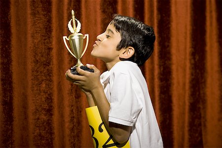 simsearch:640-02774365,k - Boy kissing trophy cup Stock Photo - Premium Royalty-Free, Code: 640-01575001