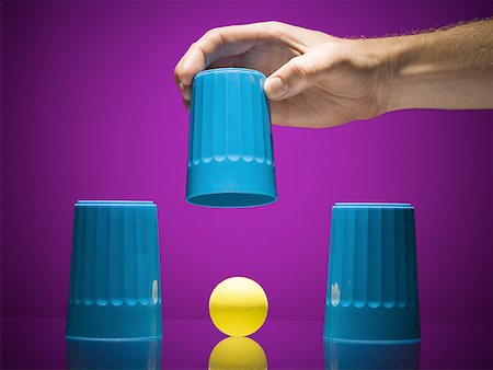 Man lifting cup to reveal ball Stock Photo - Premium Royalty-Free, Code: 640-01575028