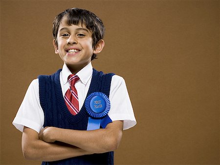 Boy with first place ribbon and arms crossed smiling Stock Photo - Premium Royalty-Free, Code: 640-01575085