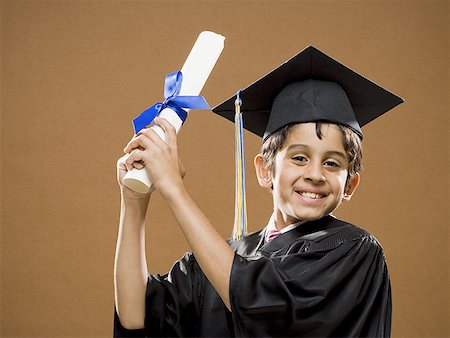 Boy graduate with mortar board and diploma smiling Stock Photo - Premium Royalty-Free, Code: 640-01575096
