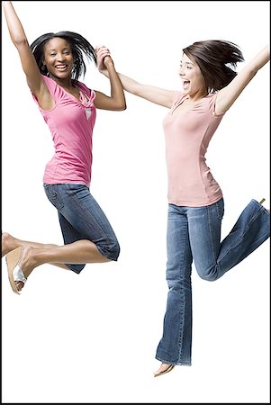 Two women holding hands and jumping Stock Photo - Premium Royalty-Free, Code: 640-01575235