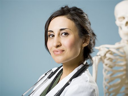 photograph woman and skeleton - Female doctor smiling with skeleton in background Stock Photo - Premium Royalty-Free, Code: 640-01575268