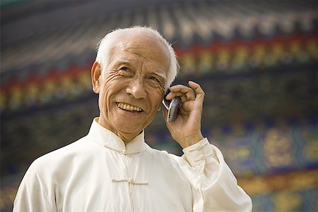 Man talking on cell phone outdoors smiling Stock Photo - Premium Royalty-Free, Code: 640-01601377