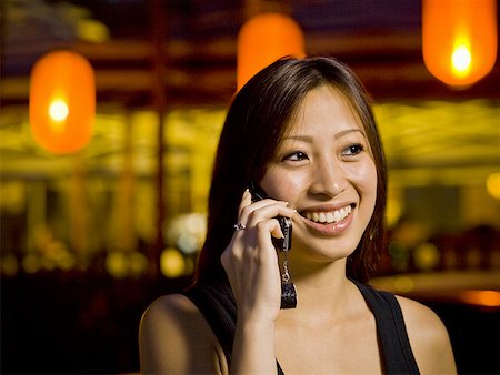 simsearch:640-01601405,k - Woman talking on a cell phone outdoors at night smiling Foto de stock - Royalty Free Premium, Número: 640-01601405