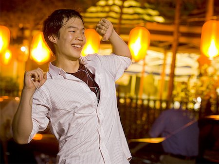 people dancing in night club with arms in air - Man with mp3 player dancing and smiling outdoors Stock Photo - Premium Royalty-Free, Code: 640-01601407