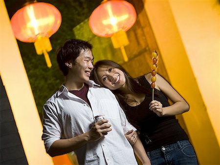 simsearch:640-02772458,k - Couple embracing outdoors with food and beverage smiling Stock Photo - Premium Royalty-Free, Code: 640-01601411