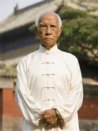 simsearch:640-01601473,k - Man standing outdoors with pagoda in background Foto de stock - Royalty Free Premium, Número: 640-01601474