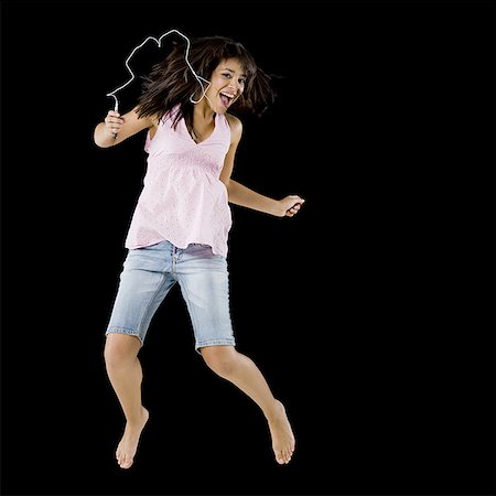 simsearch:640-02775245,k - Woman with mp3 player leaping and smiling Stock Photo - Premium Royalty-Free, Code: 640-01601563