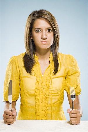 Woman with fork and knife in fists Stock Photo - Premium Royalty-Free, Code: 640-01601585