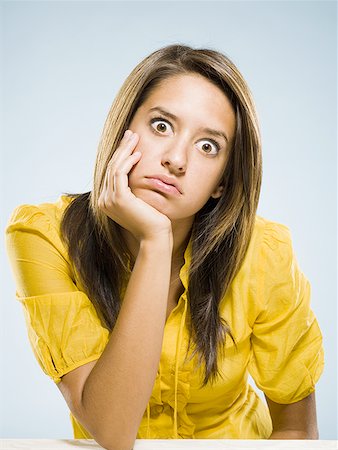 Bored woman sitting and staring Stock Photo - Premium Royalty-Free, Code: 640-01601587