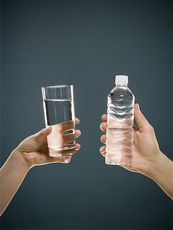 Hand holding glass of water and hand holding bottled water Stock Photo - Premium Royalty-Free, Code: 640-01601597