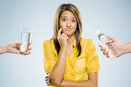 Woman choosing between glass of water and bottled water Stock Photo - Premium Royalty-Free, Code: 640-01601592