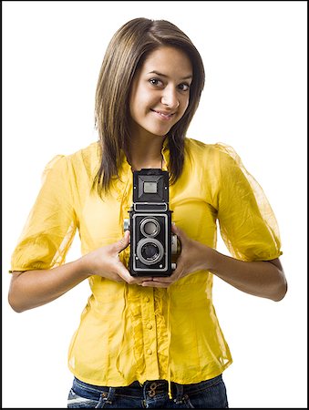 Woman holding old fashioned camera smiling Stock Photo - Premium Royalty-Free, Code: 640-01601608