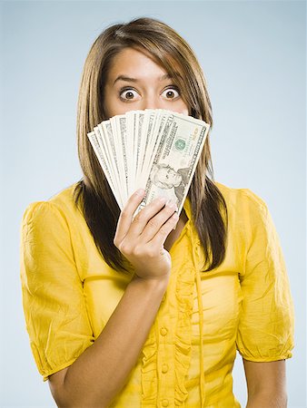 Woman with handful of money Stock Photo - Premium Royalty-Free, Code: 640-01601602