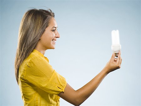 Woman holding fluorescent lightbulb Stock Photo - Premium Royalty-Free, Code: 640-01601603