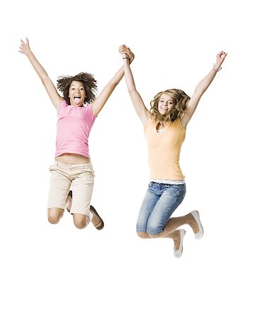 Two girls with braces holding hands and leaping Stock Photo - Premium Royalty-Free, Code: 640-01601647