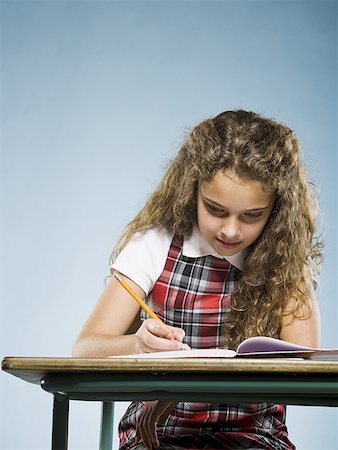 school kids work - Fille assise au bureau avec l'écriture de classeur Photographie de stock - Premium Libres de Droits, Code: 640-01601692