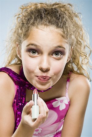 photo of girl with beauty product - Closeup of girl applying lipstick Foto de stock - Sin royalties Premium, Código: 640-01601714