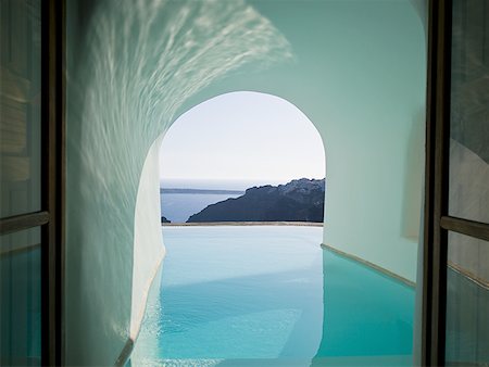 pools interior exterior - View of infinity pool through archway with mountains and water Stock Photo - Premium Royalty-Free, Code: 640-01601736