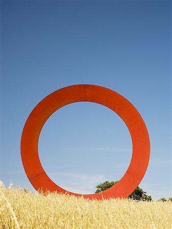 Giant red O in field with blue sky Foto de stock - Sin royalties Premium, Código: 640-01601774