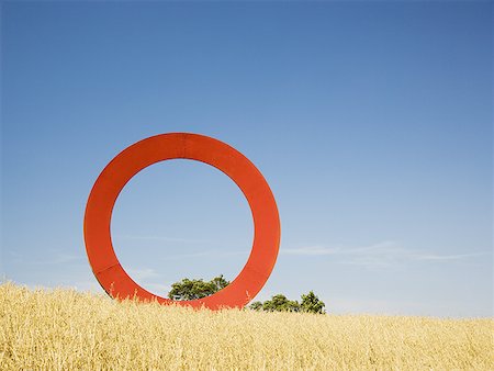 Giant red O in field with blue sky Foto de stock - Sin royalties Premium, Código: 640-01601775