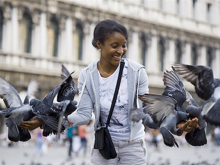 simsearch:640-01601762,k - Femme sur une place publique avec des pigeons souriant Photographie de stock - Premium Libres de Droits, Code: 640-01601781