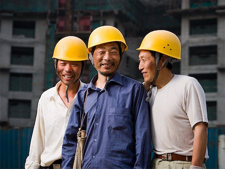 Three male construction workers with helmets outdoors smiling Stock Photo - Premium Royalty-Free, Code: 640-01645340