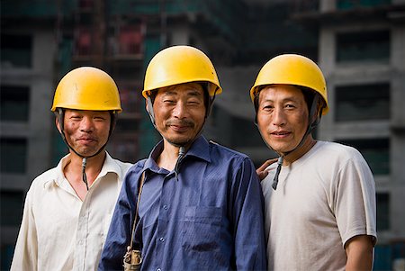 Three male construction workers with helmets outdoors smiling Stock Photo - Premium Royalty-Free, Code: 640-01645341